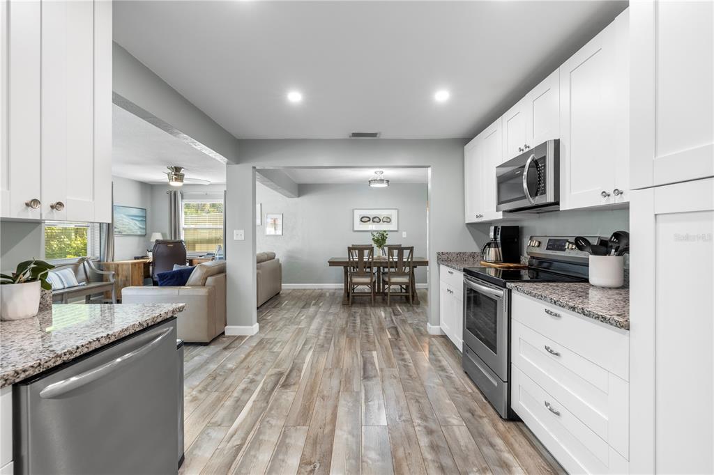 11781 68th Avenue Seminole, FL 33772 - Photo 18 of 60 a kitchen with granite countertop lots of counter top space a sink appliances and cabinets