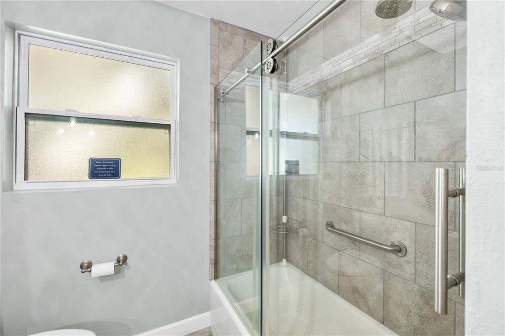 11781 68th Avenue Seminole, FL 33772 - Photo 28 of 60 a bathroom with a glass shower door