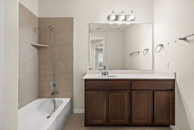 a bathroom with a double vanity sink mirror and bathtub