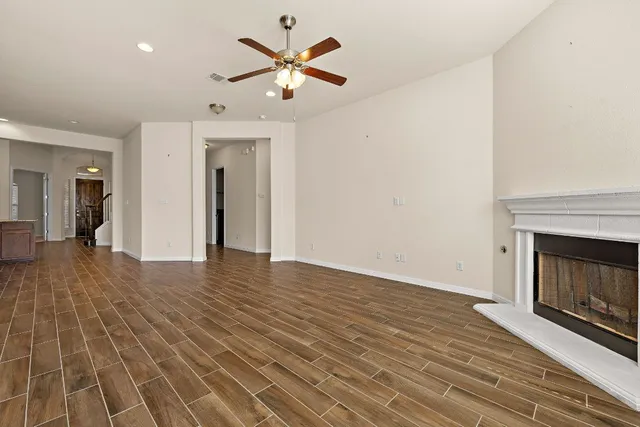 an empty room with wooden floor and a fireplace