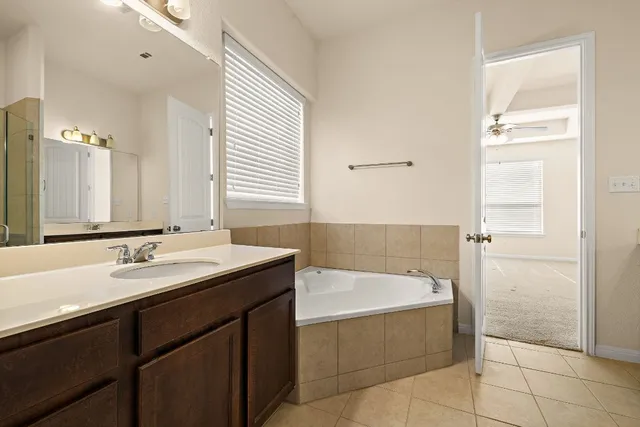 a bathroom with a tub sink and mirror