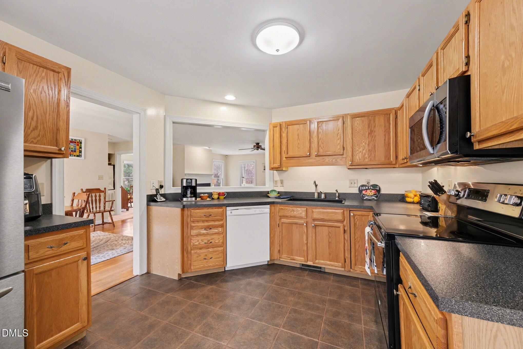 2404 Bane Road Efland, NC 27243 - Photo 14 of 46 a kitchen with stainless steel appliances granite countertop a stove top oven a sink a refrigerator and white cabinets