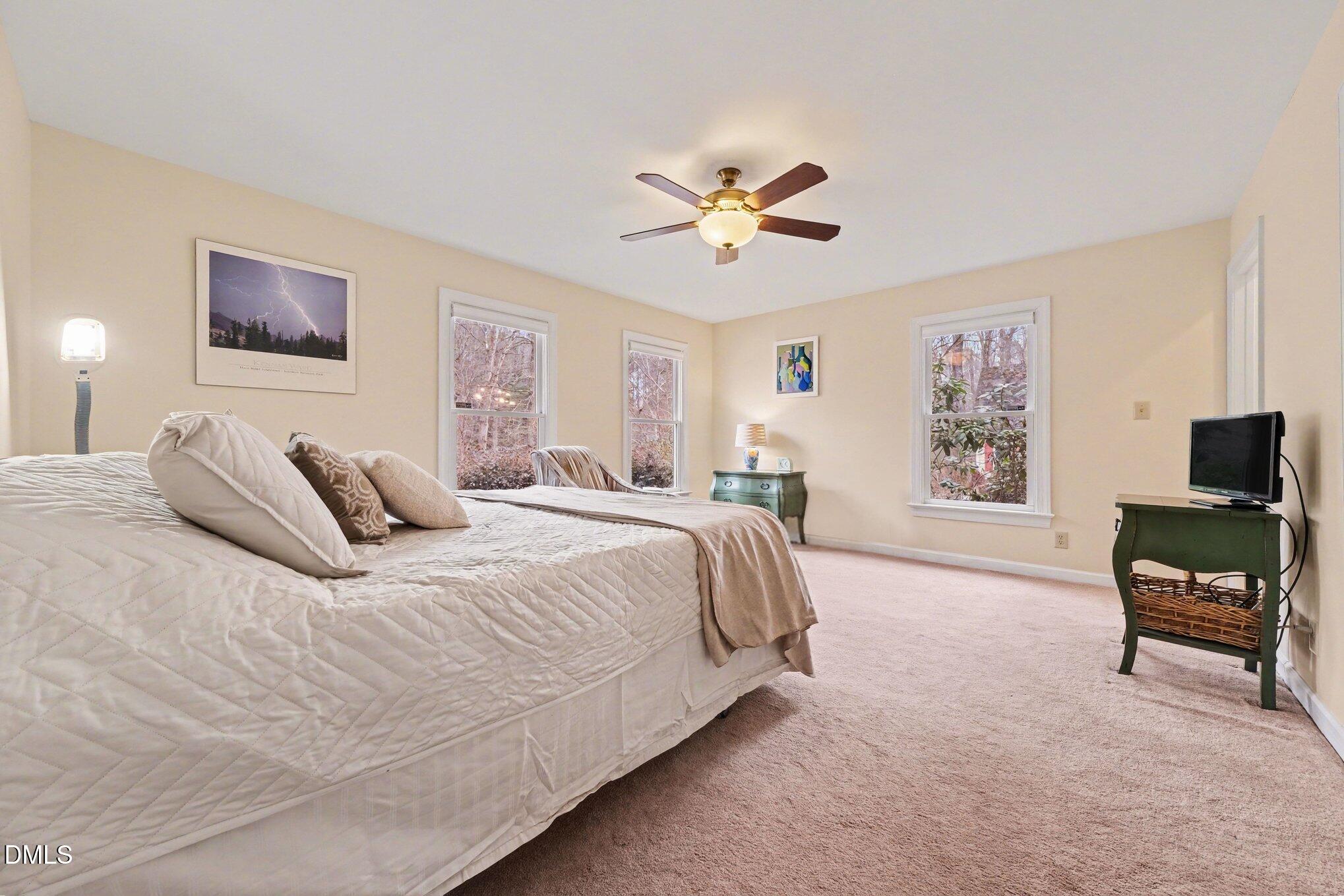 2404 Bane Road Efland, NC 27243 - Photo 19 of 46 a spacious bedroom with a bed a couch and a window