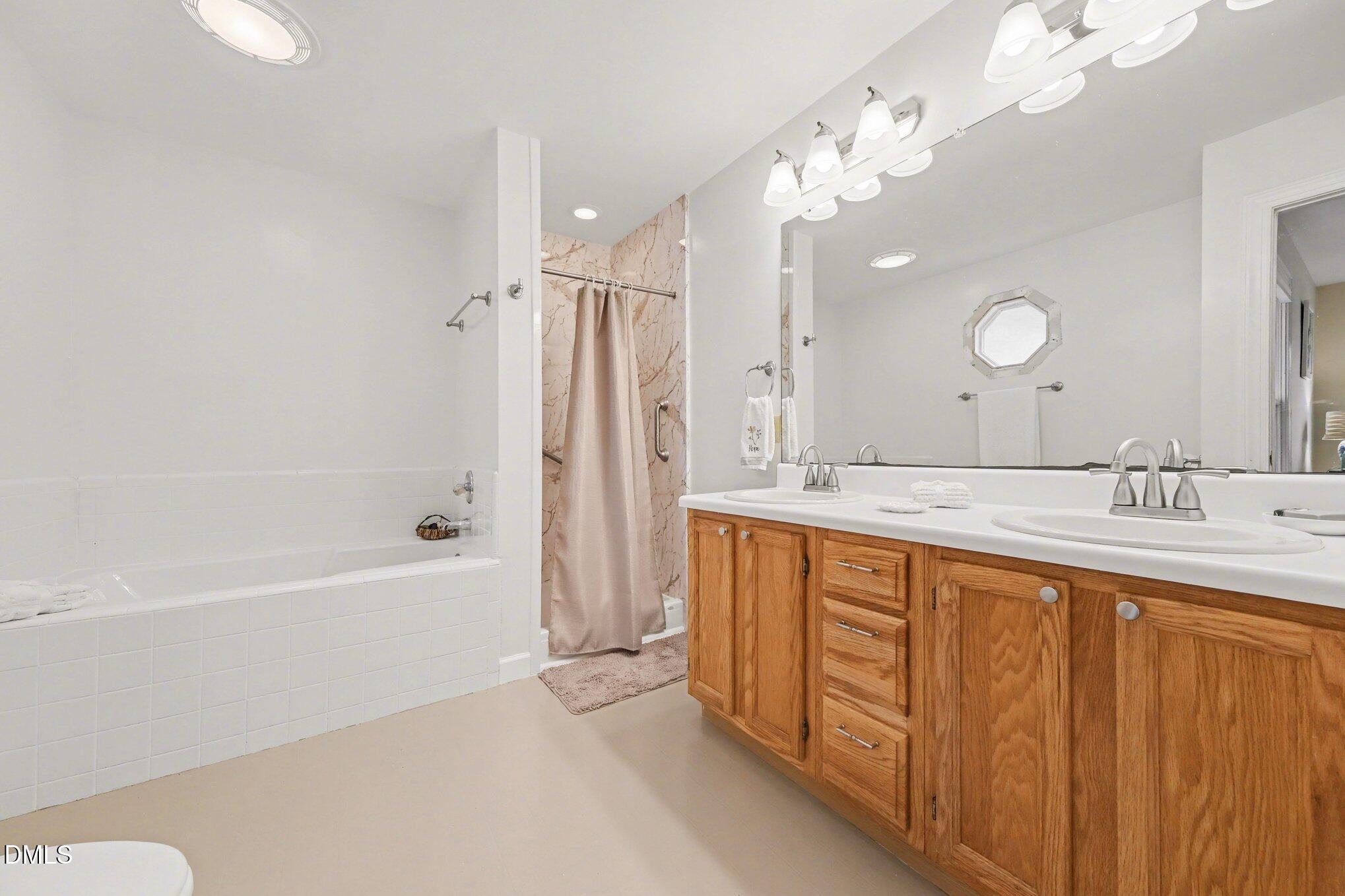 2404 Bane Road Efland, NC 27243 - Photo 20 of 46 a spacious bathroom with a bathtub shower sink and mirror