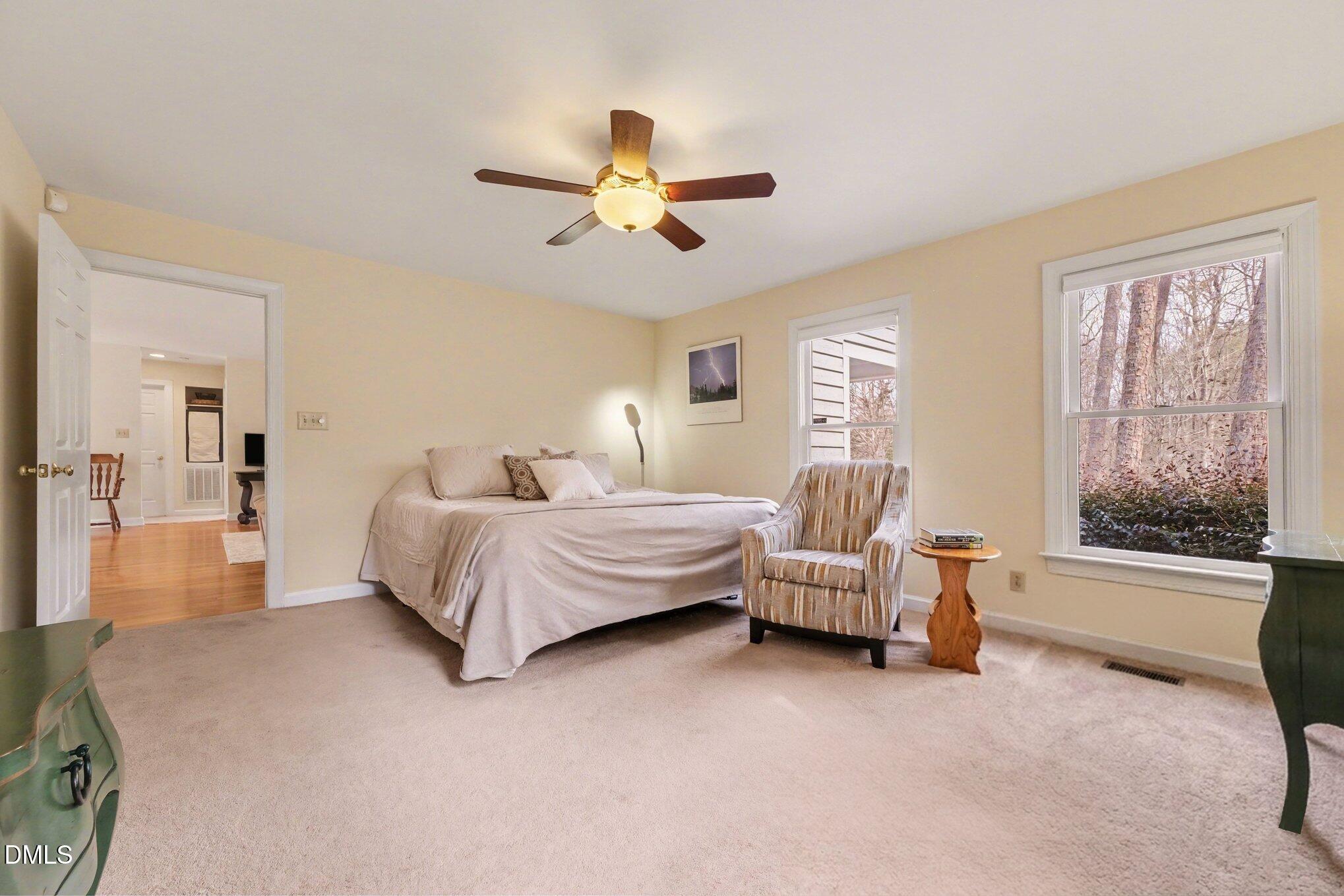 2404 Bane Road Efland, NC 27243 - Photo 22 of 46 a spacious bedroom with a bed and a chandelier