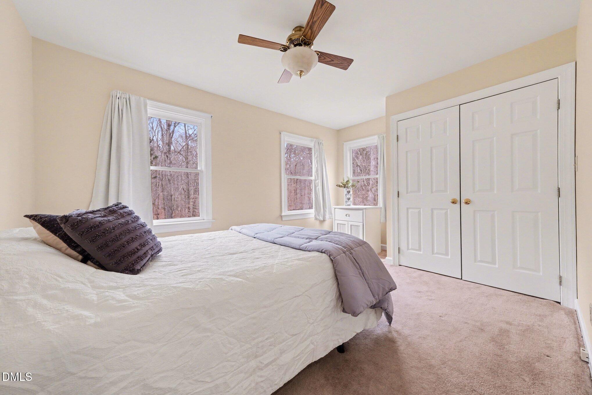 2404 Bane Road Efland, NC 27243 - Photo 26 of 46 a bedroom with a large bed and a chandelier