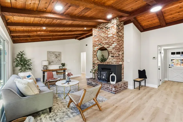 a living room with furniture a rug and a floor to ceiling window