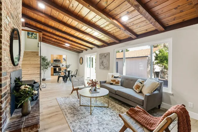 a bedroom with a bed and a lamp on table with wooden floor