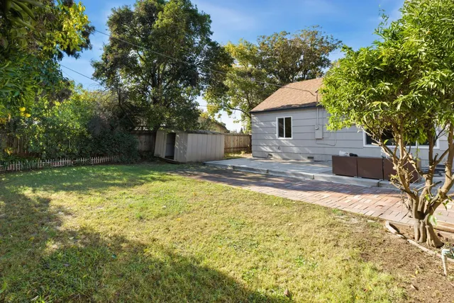 a view of a house with backyard and a tree