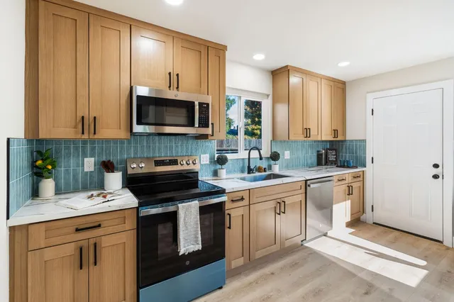 a kitchen with cabinets stainless steel appliances and a sink