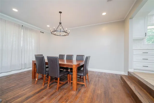 a view of a dining room with furniture wooden floor and chandelier