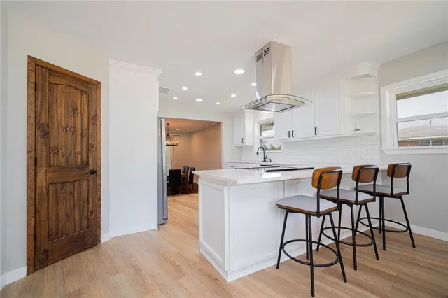 a kitchen with kitchen island granite countertop wooden cabinets and white appliances
