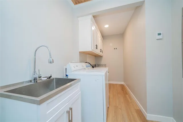 a kitchen with a sink and a stove with wooden floor