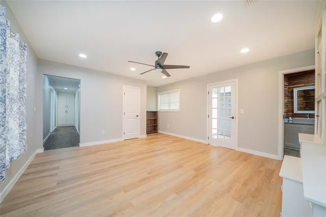 a view of empty room with wooden floor and windows