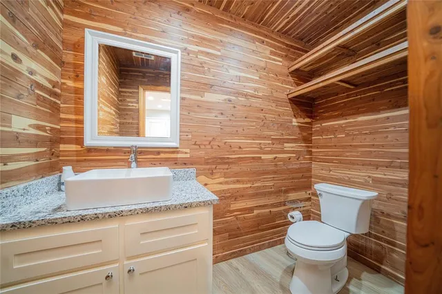 a bathroom with a granite countertop toilet and sink