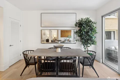 a view of a dining room and livingroom with furniture window and wooden floor