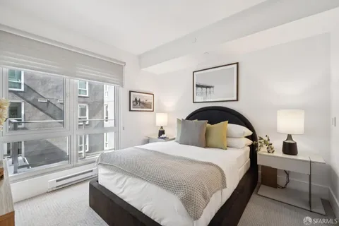 a bedroom with a large bed and a painting on the wall