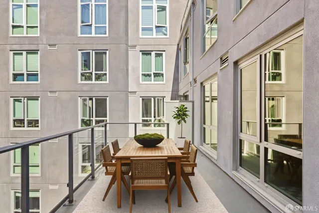a view of a brick building with a dining table and chairs