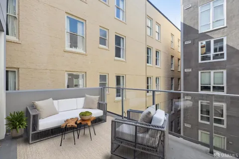 a view of a patio with couches chairs and wooden floor
