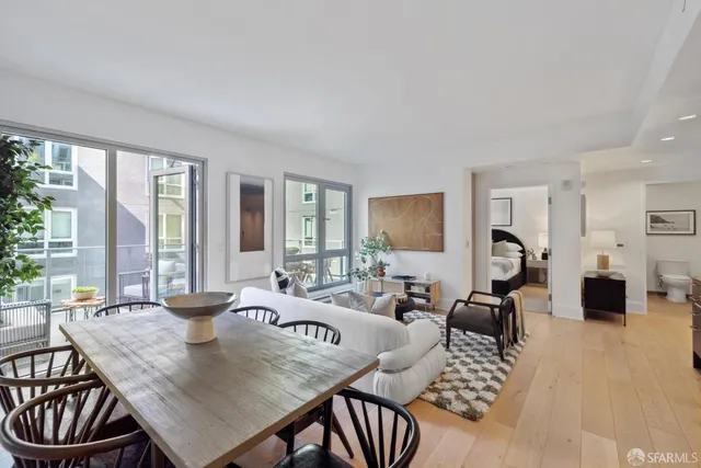 a living room with furniture a large window and wooden floor