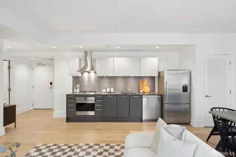 a large kitchen with stainless steel appliances kitchen island granite countertop a refrigerator and a stove top oven