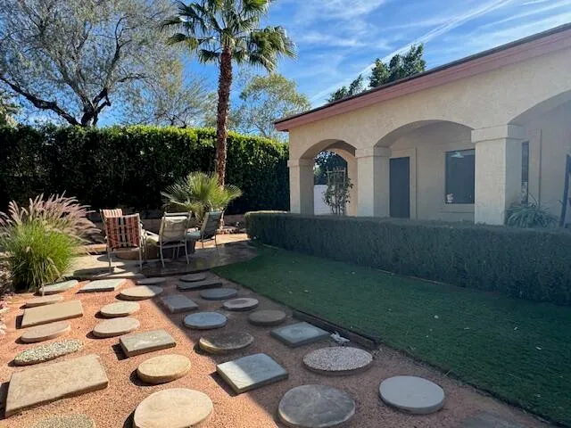 a view of a patio with couches table and chairs potted plants and palm tree