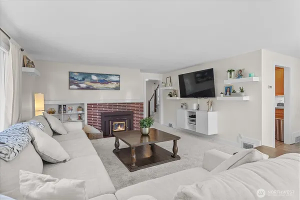 a living room with furniture a flat screen tv and a fireplace