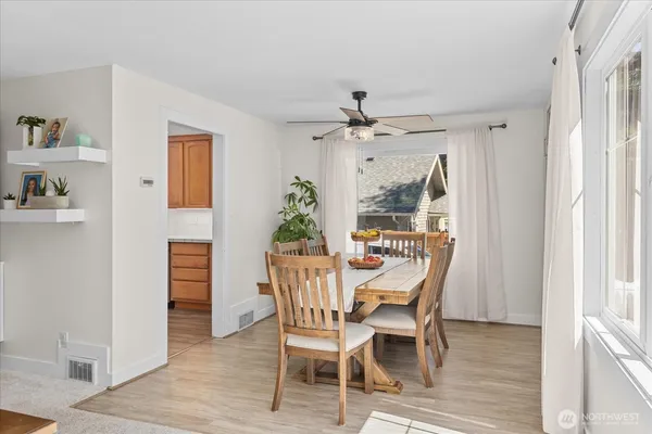 a dining room with furniture potted plants and wooden floor