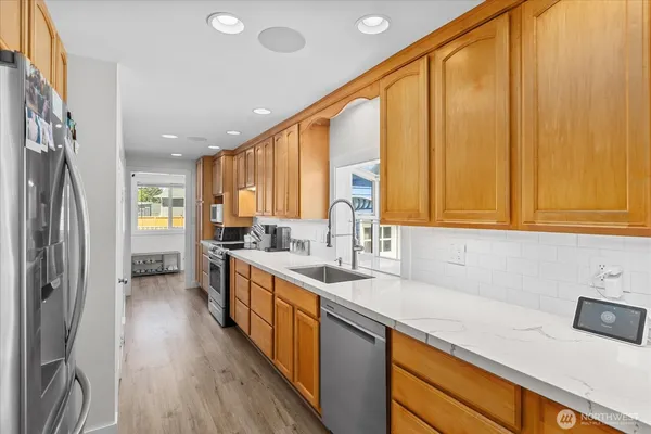 a kitchen with a sink a refrigerator and cabinets