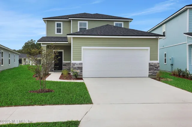 a front view of a house with a yard and garage
