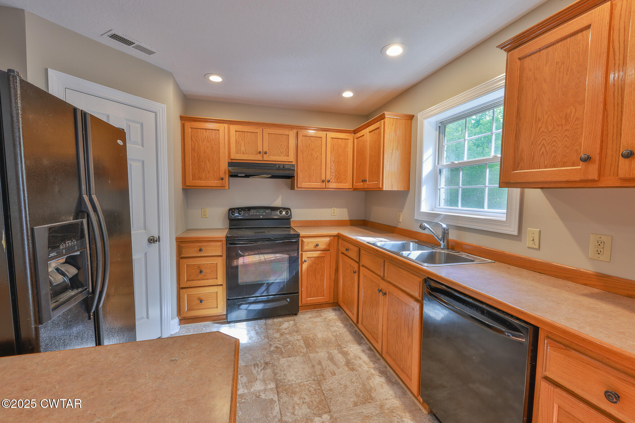 679 North Main Street Dyer, TN 38330 - Photo 14 of 25 a kitchen with stainless steel appliances granite countertop a refrigerator and a sink