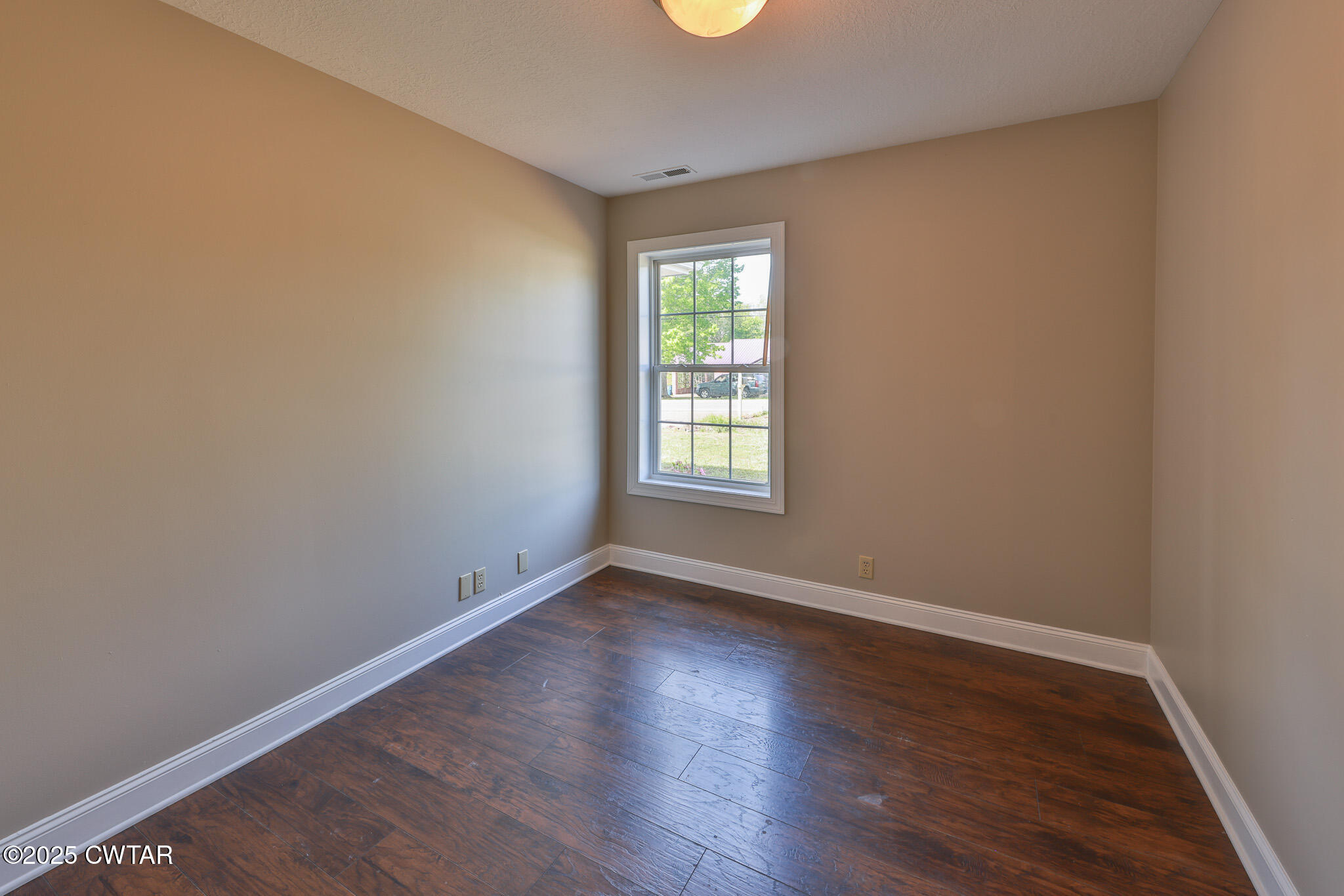 679 North Main Street Dyer, TN 38330 - Photo 19 of 25 an empty room with wooden floor and windows