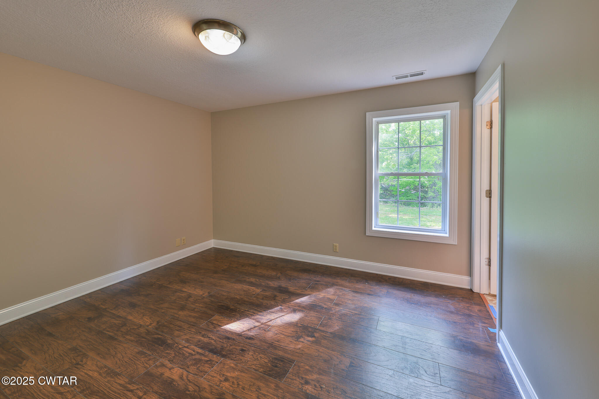 679 North Main Street Dyer, TN 38330 - Photo 22 of 25 an empty room with wooden floor and windows