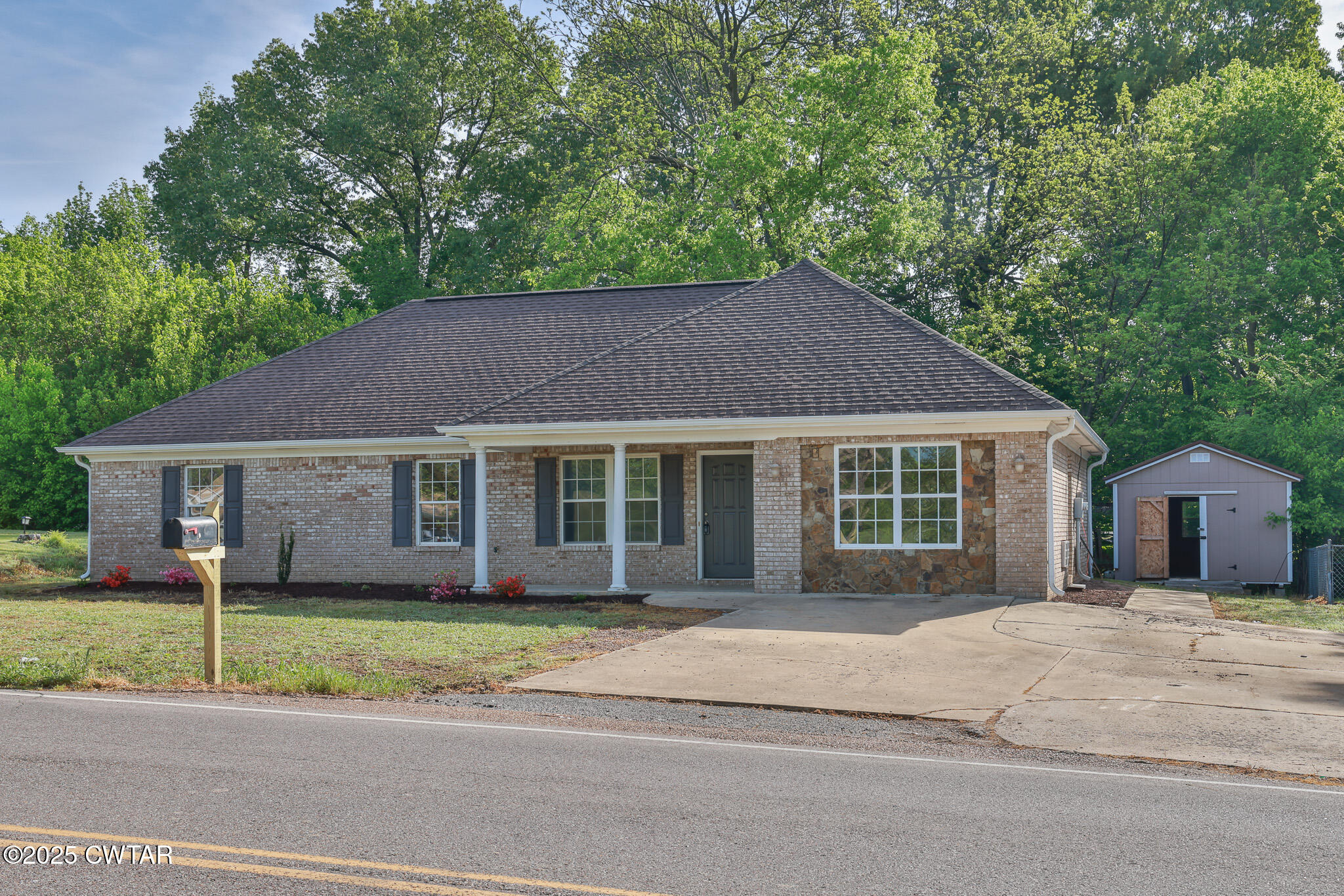 679 North Main Street Dyer, TN 38330 - Photo 3 of 25 a front view of a house with a garden and trees