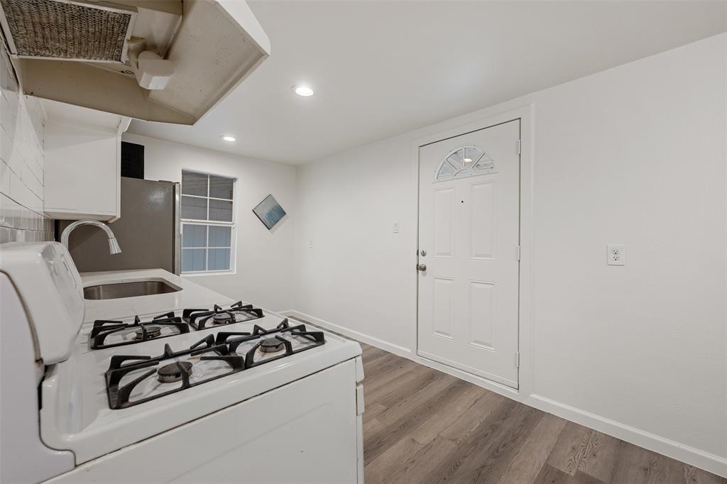 901 Valdez Street, Unit A Austin, TX 78741 - Photo 13 of 16 Kitchen featuring white gas range oven, ventilation hood, recessed lighting, wood-look vinyl flooring, and light countertops