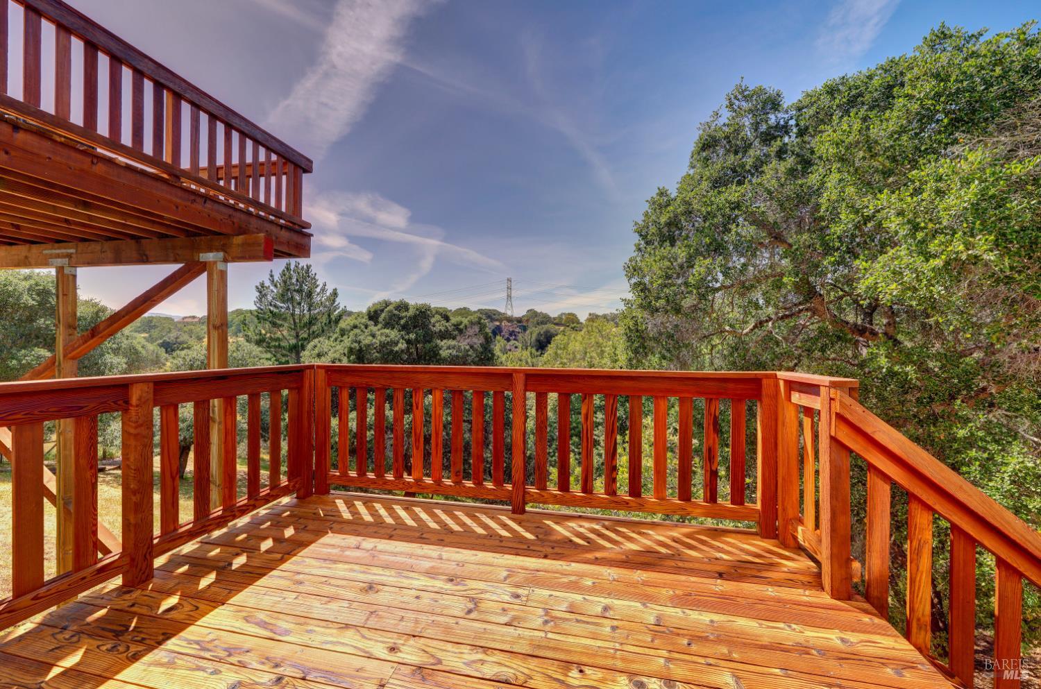10 Lockton Lane Novato, CA 94945 - Photo 53 of 68 Lower-level deck surrounded by trees, extending the home’s outdoor living options across multiple levels.