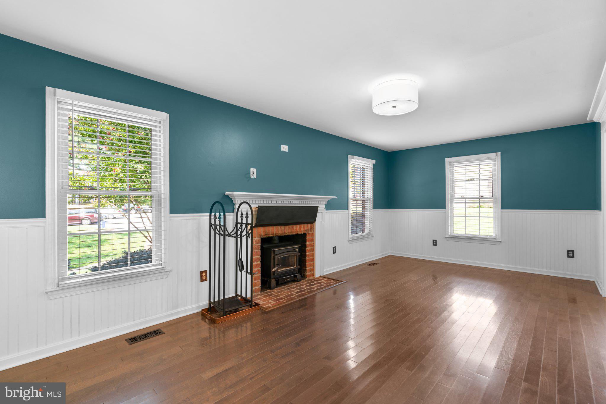 1000 Windrush Lane, Unit 18 Sandy Spring, MD 20860 - Photo 7 of 35 an empty room with windows a fireplace and wooden floor