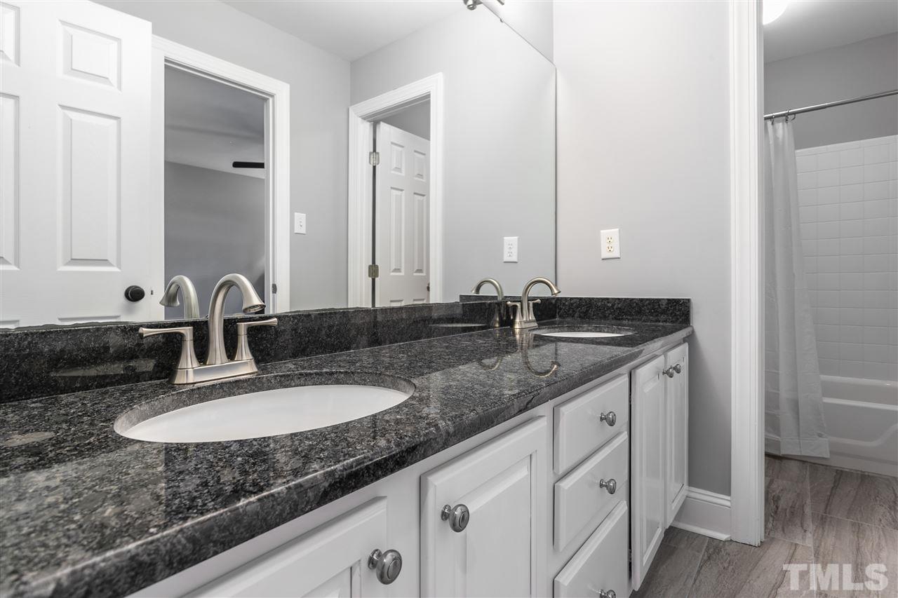 8005 Kukui Court Raleigh, NC 27613 - Photo 14 of 30 a bathroom with double sink and a mirror