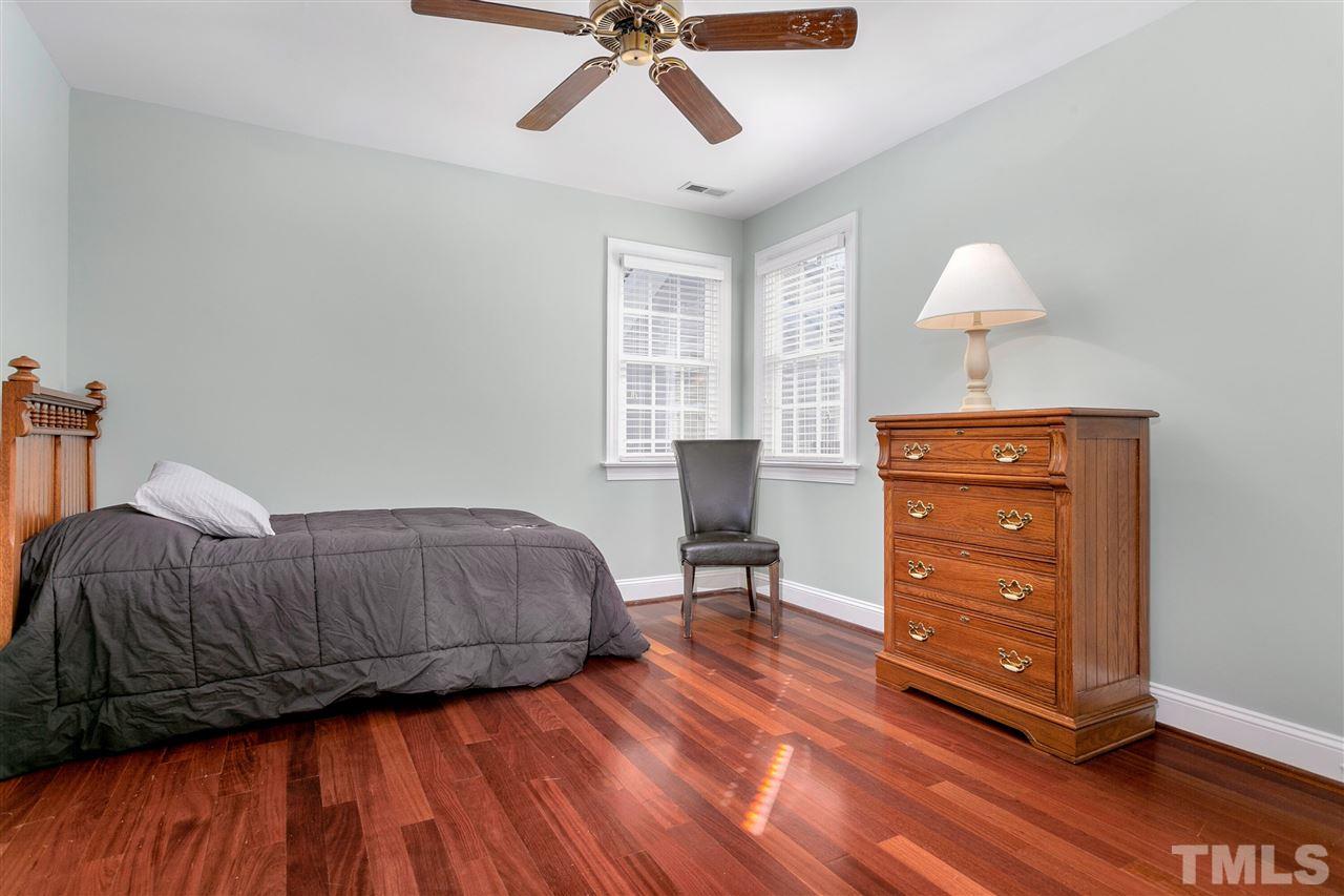 8005 Kukui Court Raleigh, NC 27613 - Photo 16 of 30 a bedroom with a bed and wooden floor