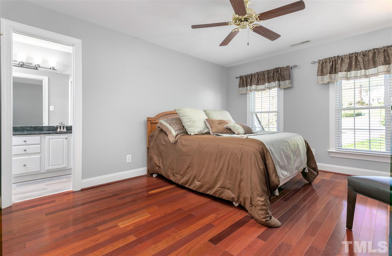8005 Kukui Court Raleigh, NC 27613 - Photo 17 of 30 a spacious bedroom with a bed and wooden floor