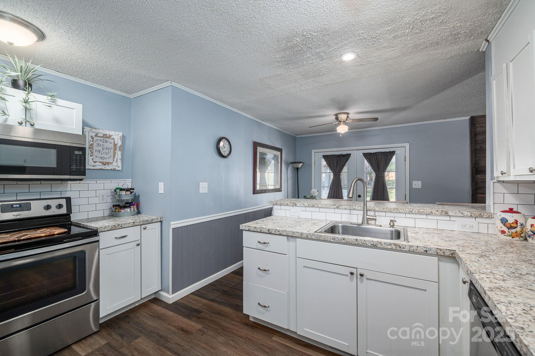 109 White Rock Road Grover, NC 28073 - Photo 11 of 37 a kitchen with granite countertop a sink stainless steel appliances and white cabinets