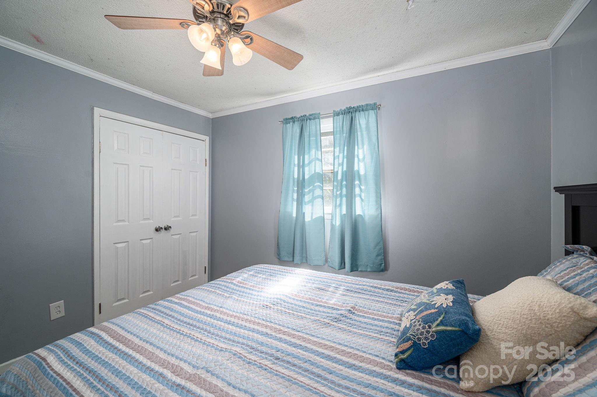 109 White Rock Road Grover, NC 28073 - Photo 16 of 37 a bedroom with a bed and a chandelier