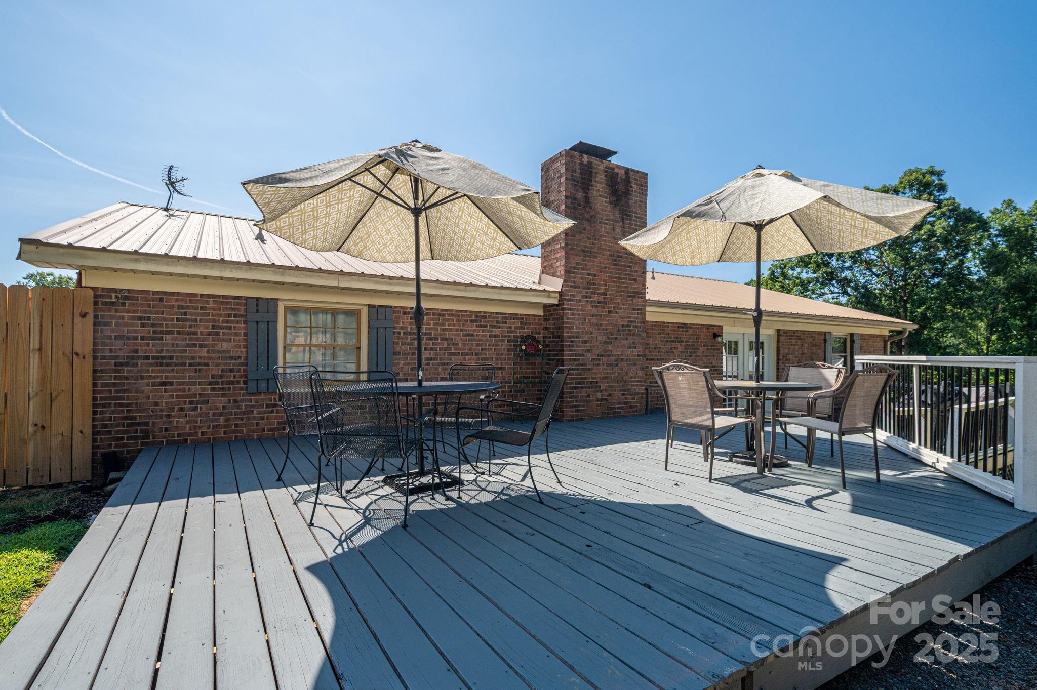 109 White Rock Road Grover, NC 28073 - Photo 31 of 37 a view of a roof deck with table and chairs under an umbrella with wooden floor
