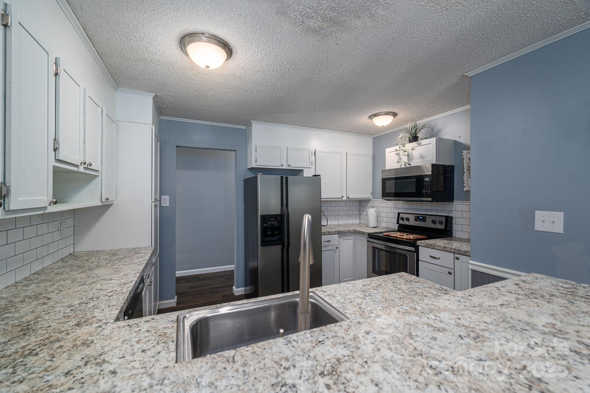 109 White Rock Road Grover, NC 28073 - Photo 7 of 37 a kitchen with stainless steel appliances kitchen island granite countertop a refrigerator stove and sink