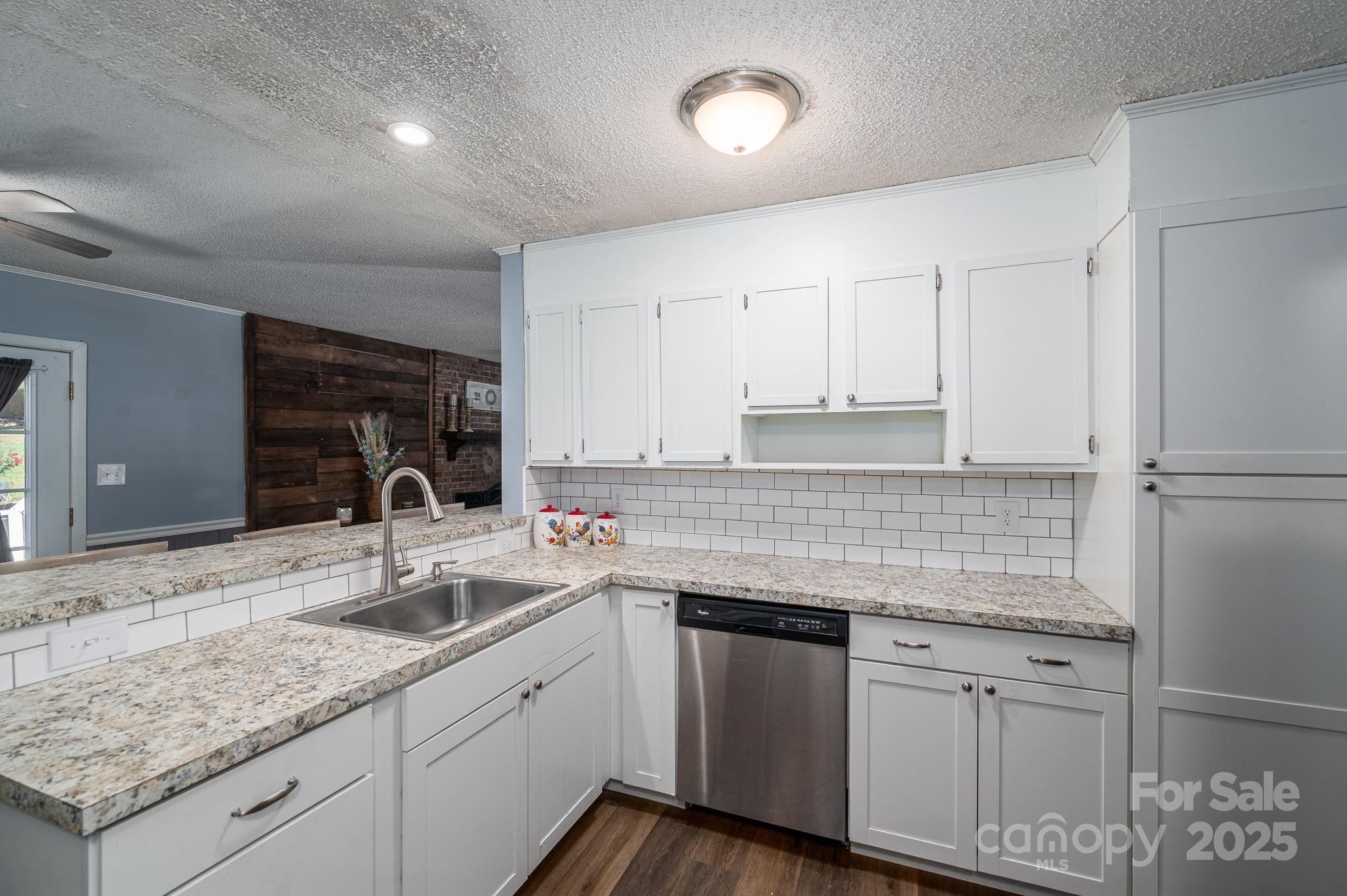 109 White Rock Road Grover, NC 28073 - Photo 9 of 37 a kitchen with granite countertop a sink and white cabinets