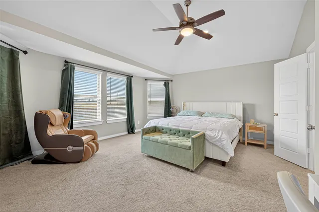 a spacious bedroom with a bed a couch and a large window