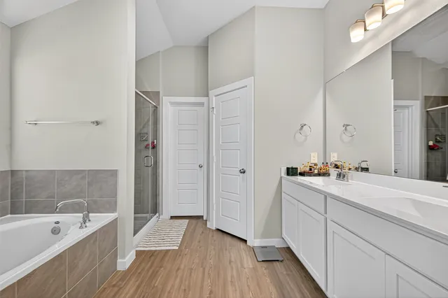 a bathroom with a tub a sink and mirrors
