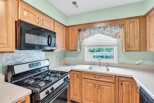 a kitchen with stainless steel appliances a sink stove and cabinets