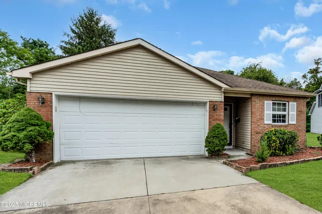a view of a house with garage and plants
