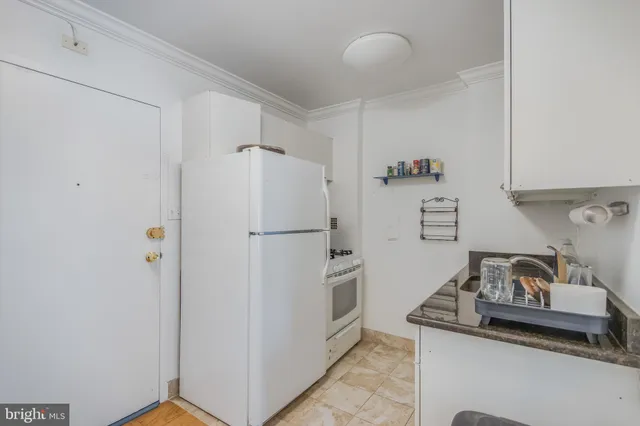 a white refrigerator freezer and a stove sitting inside of a kitchen